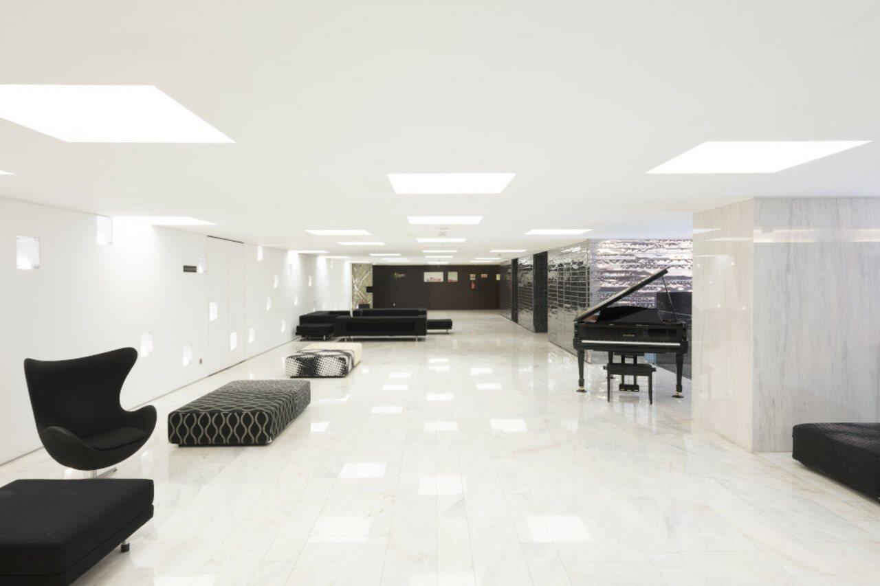Vip Grand Lisboa Hotel & Spa Exterior photo The photo shows a spacious, modern interior with a polished marble floor. The room features minimalist decor and ample natural light, coming from square ceiling lights. There are several sleek, dark-colored seating options, including a distinctive bl